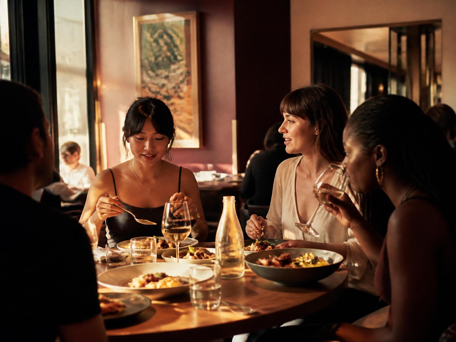 Guests sharing plates at a warmly lit restaurant table